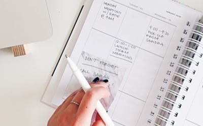 Agenda papier ouvert avec notes manuscrites et stylo sur un bureau