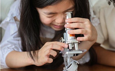 Enfant observant un échantillon au microscope