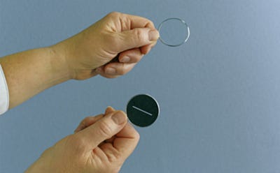 Comparaison entre un verre correcteur transparent et un verre teinté tenu dans les mains