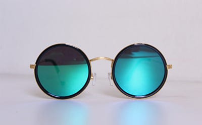 Paire de lunettes de soleil rondes avec verres miroir bleus sur fond clair