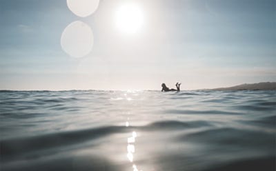 Personne flottant à la surface de la mer sous un soleil éclatant