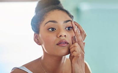 Femme touchant le contour de son œil, illustrant la durée de port des lentilles