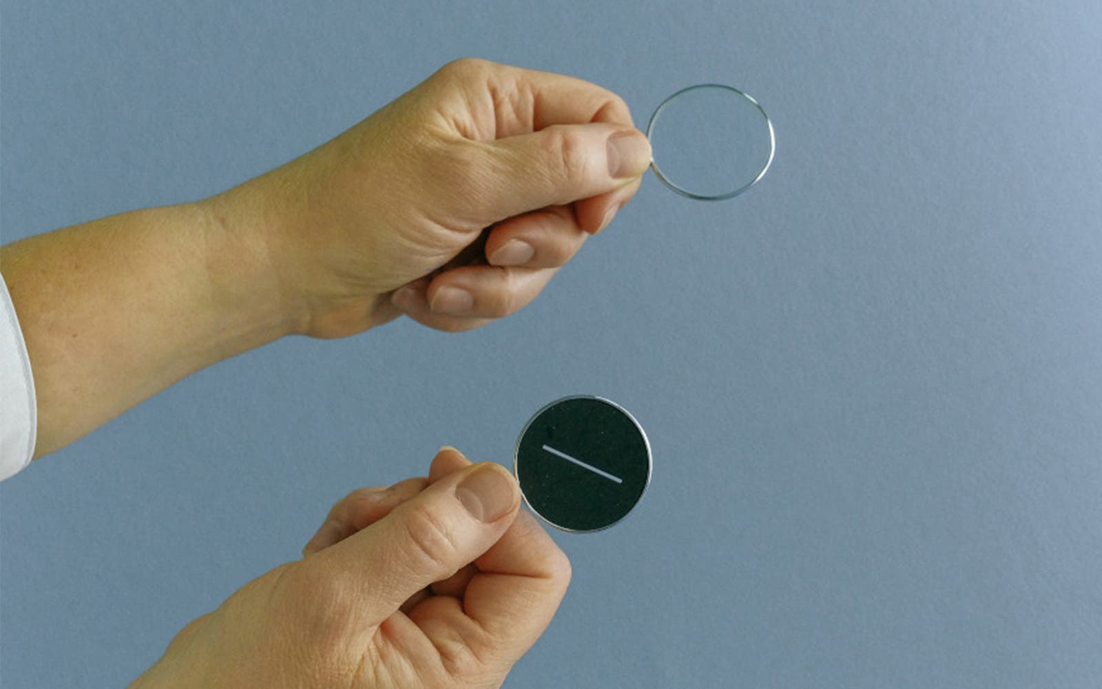 Comparaison entre un verre correcteur transparent et un verre teinté tenu dans les mains