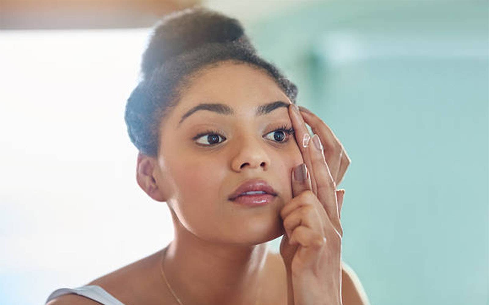 Femme touchant le contour de son œil, illustrant la durée de port des lentilles