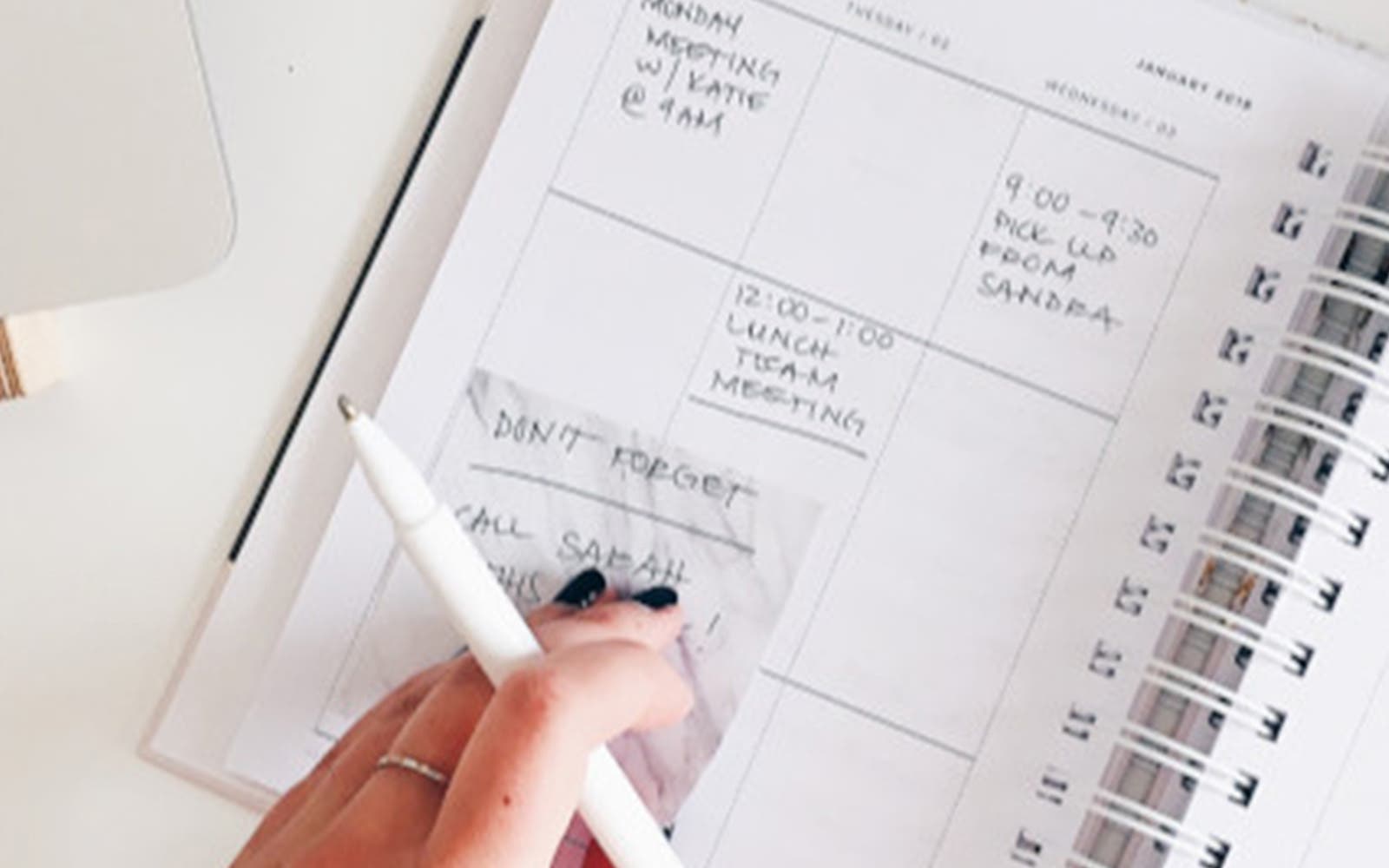 Agenda papier ouvert avec notes manuscrites et stylo sur un bureau