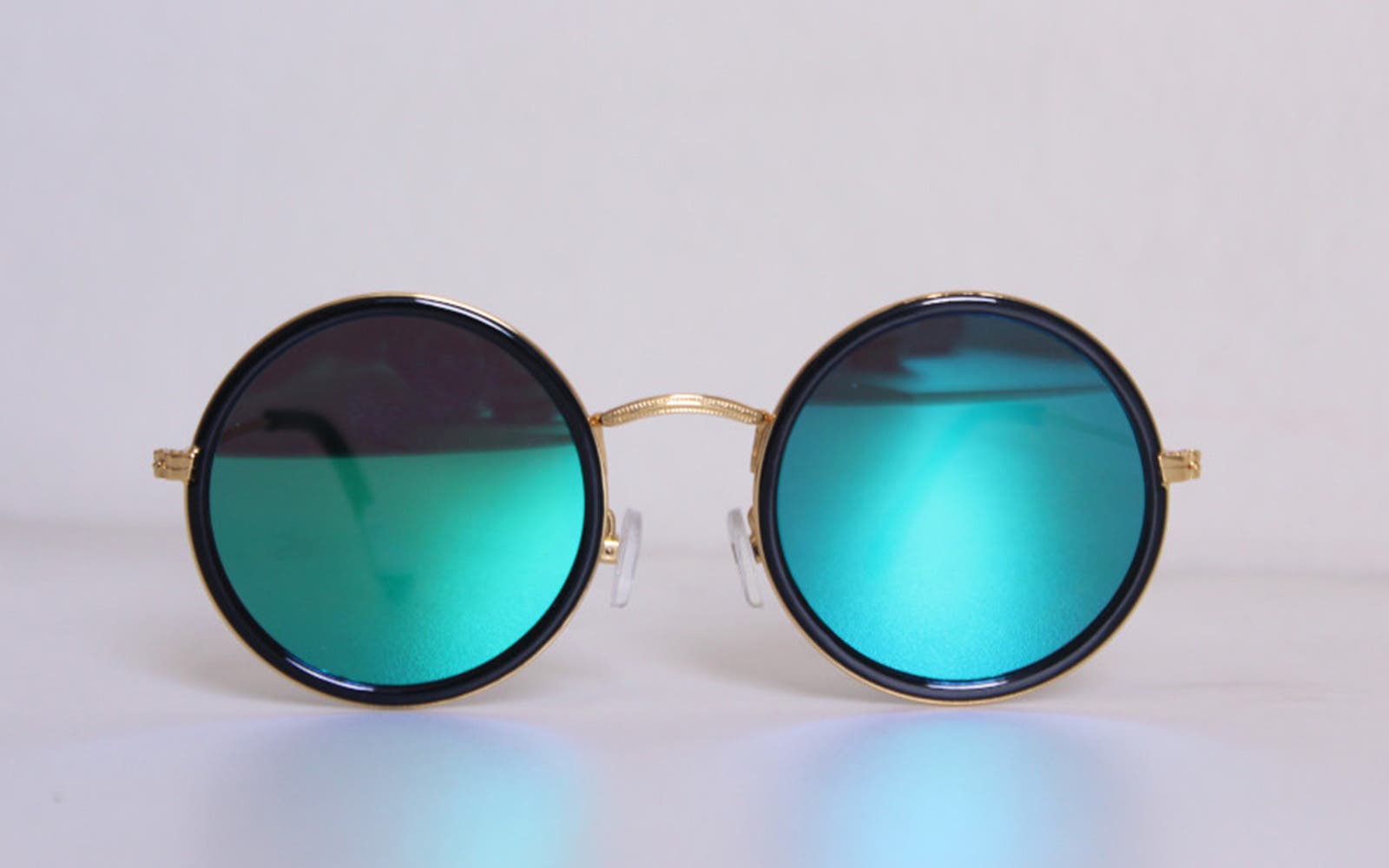 Paire de lunettes de soleil rondes avec verres miroir bleus sur fond clair