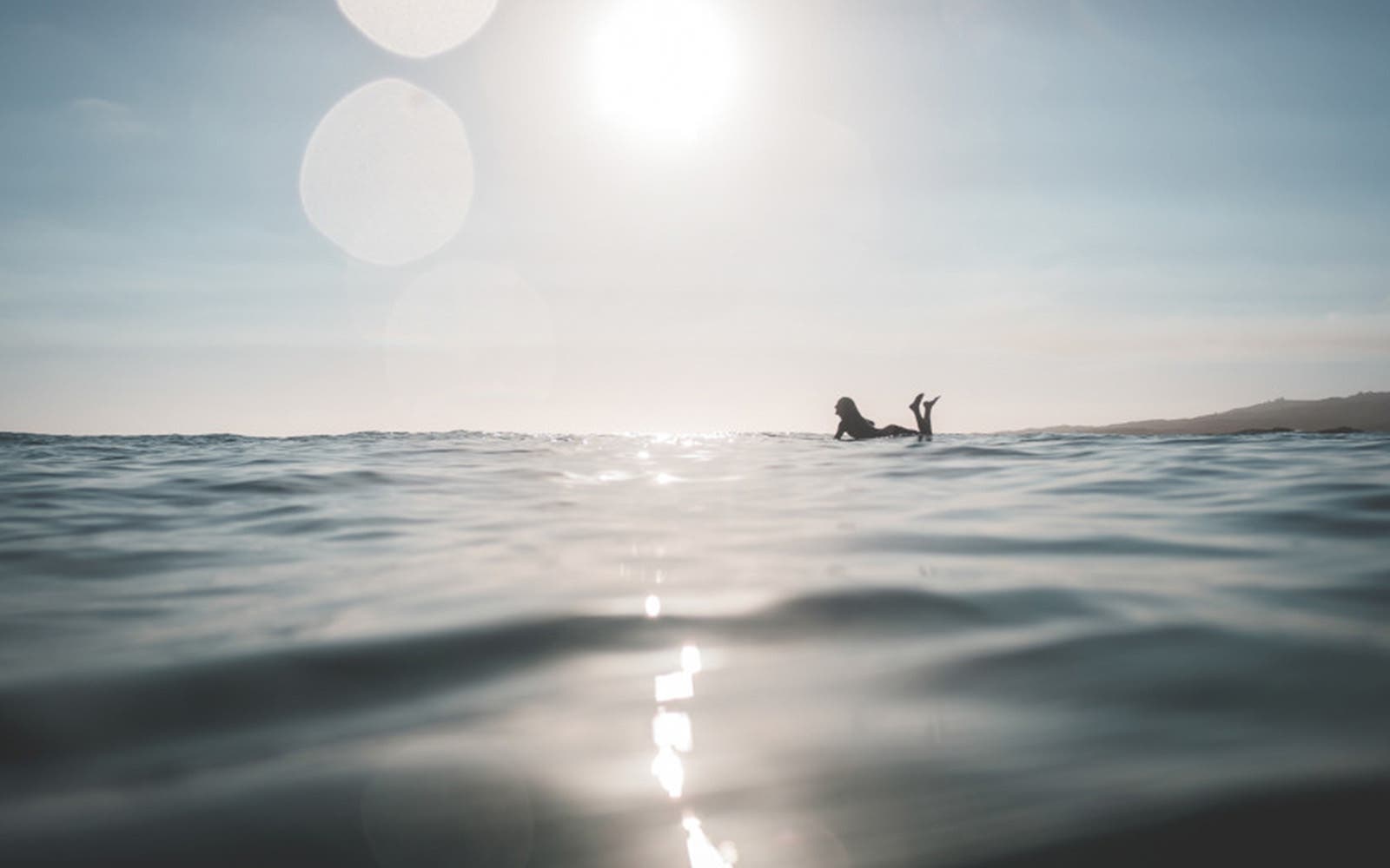 Personne flottant à la surface de la mer sous un soleil éclatant